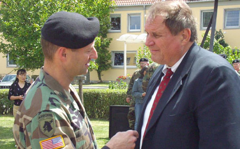 Col. Raymond Palumbo, commander of the 12th Aviation Brigade, talks with Ron Smith, whose son Chief Warrant Officer 2 J.D. Smith was killed in February 2003 after his UH-60 Black Hawk helicopter crashed in Kuwait. On Friday, members of the 5th Battalion, 158th Aviation Regiment gathered in Giebelstadt, Germany, to dedicate a monument in memory of the two pilots and two crew chiefs who died that night.