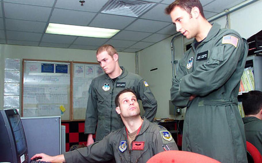 Capt. Ben Wysack, 36th Fighter Squadron, discusses flying operations with U.S. Air Force Academy Cadets Second Class Taylor Gifford, left, and Luke Rodgers during a summer training program at Osan Air Base, South Korea.
