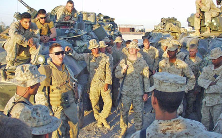 Marine 1st Lt. Knox Nunnally, left center, of Company D, 2nd Light Armored Reconnaissance Battalion, addresses his platoon at Camp Fallujah, Iraq, before it headed out on a recent night patrol.