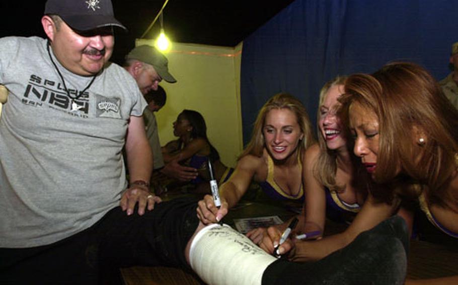 Army Master Sgt. Luis Lopez, from the 348th Personnel Group, has Baltimore Ravens cheerleaders, from left, Jenny, Michelle and Shannon sign his cast. The cheerleaders stayed after their hour-and-a-half performance to sign autographs and take pictures.