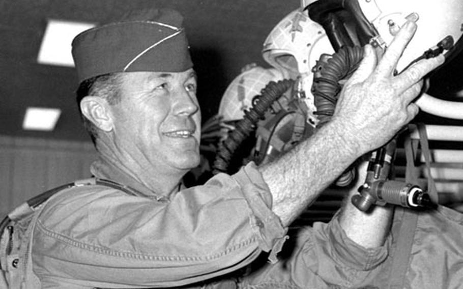 Col. Chuck Yeager, commander of the 405th Fighter Wing, picks out flying gear at the 523rd Tactical Fighter Squadron in preparation for a flight in an F-100.