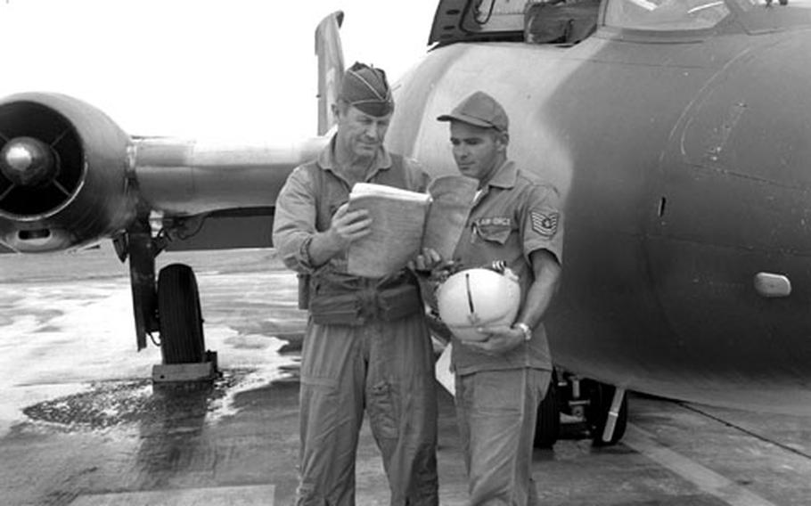 Col. Chuck Yeager and crew chief TSgt. Rodney T.J. Sirois, beside a B-57 aircraft.