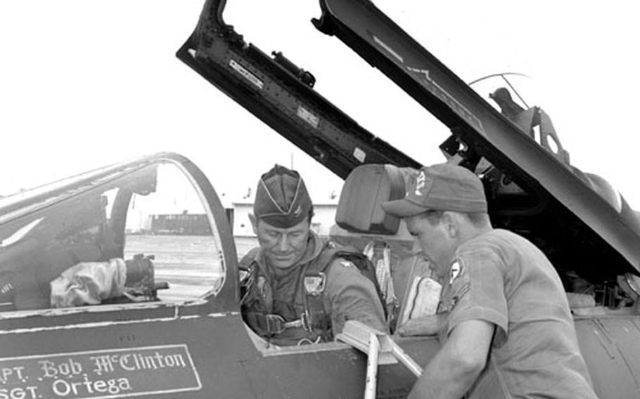 F-100 crew chief Airman 2nd Class James Rohl helps Col. Yeager settle into the cockpit.