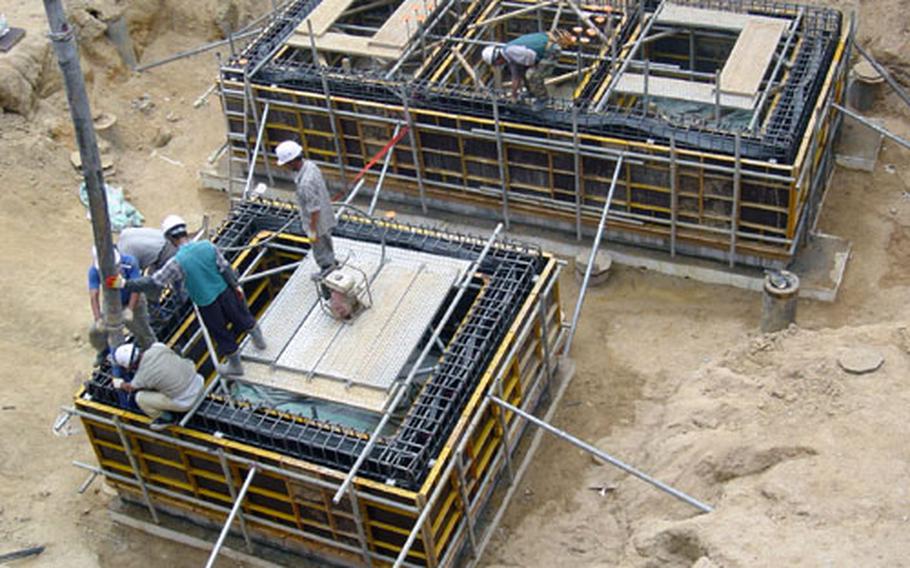 At Camp Humphreys, South Korea, workers pour concrete late last month in what will become elevator shafts of an eight-story family housing tower, one of two slated for construction at the site.