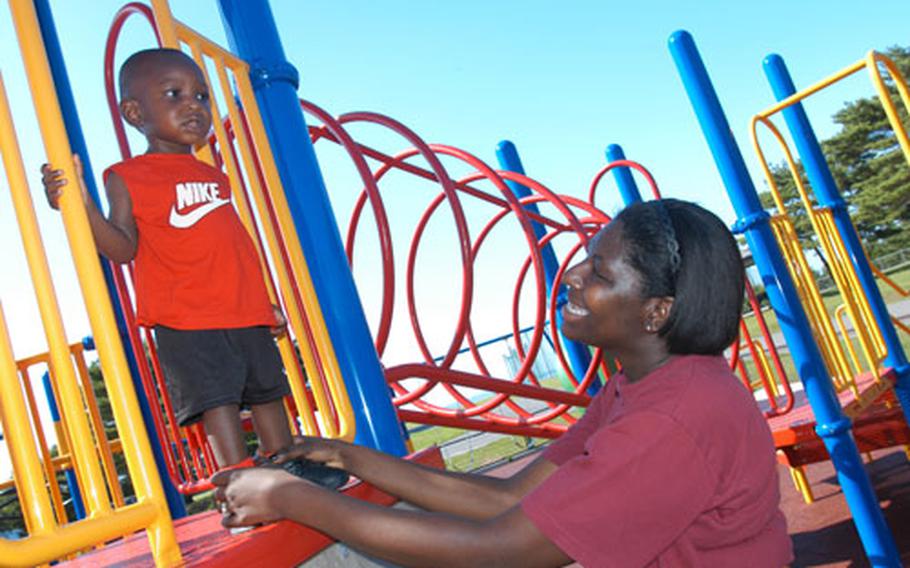 Petty Officer 2nd Class Aquinor Hollingsworth plays with 1-year-old Corey Hollingsworth Jr. on the new playground equipment at Misawa Air Base&#39;s Davey Jones&#39; Locker.
