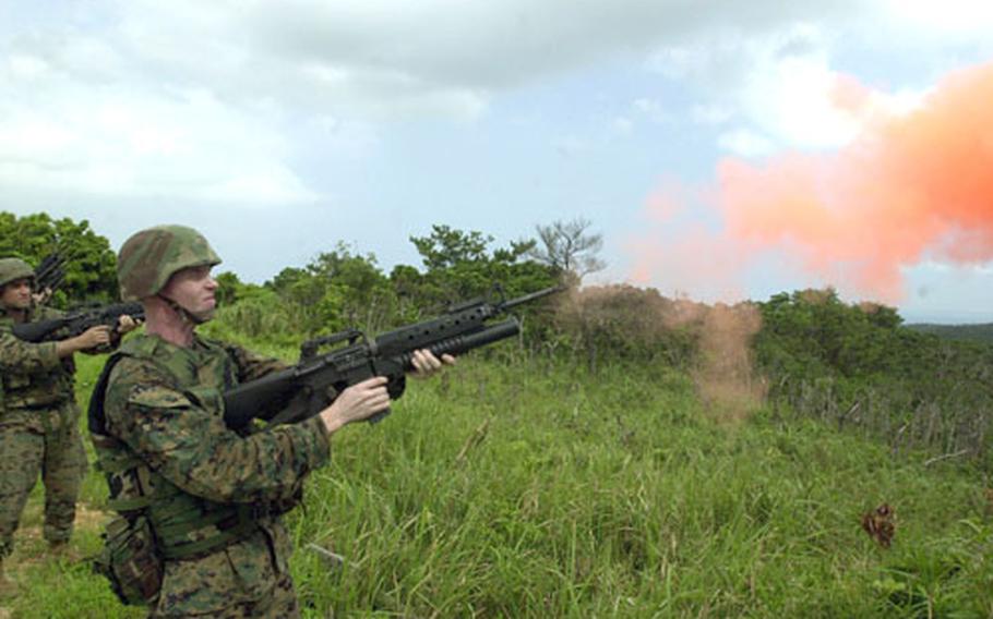 Cpl. Ryan Dankenbring, a radio operator with the 31st Marine Expeditionary Unit, fires a faulty M203 grenade practice round that broke apart and released its orange chalk.