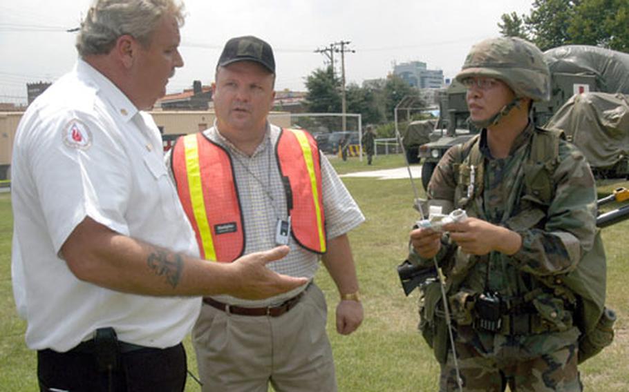 During a biological attack exercise at the Army&#39;s Camp George in Taegu, South Korea, on Thursday, emergency response officials receive from a soldier a mock report that chemical agent tests indicate the area is no longer contaminated. The soldier&#39;s report was part of the exercise scenario. At left is Area IV fire chief Bob Purvis; James Adamski, center, is director of Area IV&#39;s Directorate of Plans, Training, Mobility and Security.