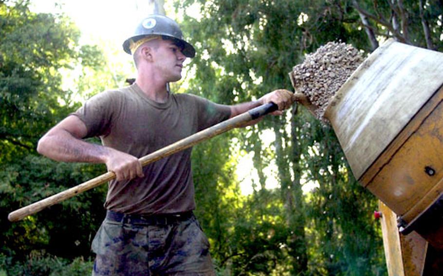 Navy Petty Officer 3rd Class Stephen Monsees of Naval Mobile Construction Battalion 74 dumps a pile into a concrete mixer at Naval Station Rota, Spain, on Tuesday.