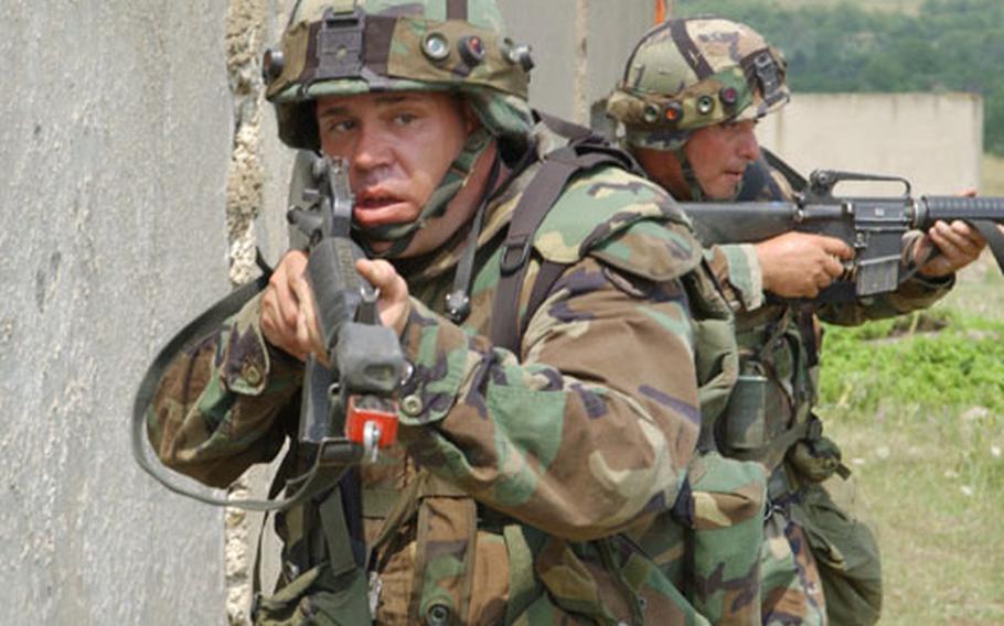 Spc. John Ronna, left, and Staff Sgt. Ron Floyd, right, of Alpha Company, 2nd Battalion, 130th Infantry Regiment of the Illinois National Guard, prepare to clear and enter a building during Multi Operations Urban Terrain exercise at the Bulwark &#39;04 exercise at the Novo Selo Training Area, Bulgaria.