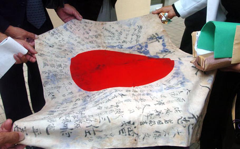 The U.S. Air Force returned a Japanese flag to Manshichi Saeki during a ceremony in front of the Yokota Air Base headquarters building on Friday. The flag belonged to Ippei Saeki, younger brother of Manshichi, who died fighting against American forces during World War II almost 60 years ago. Manshichi Ippei together with some of his brother&#39;s surviving friends attended the brief but solemn ceremony.
