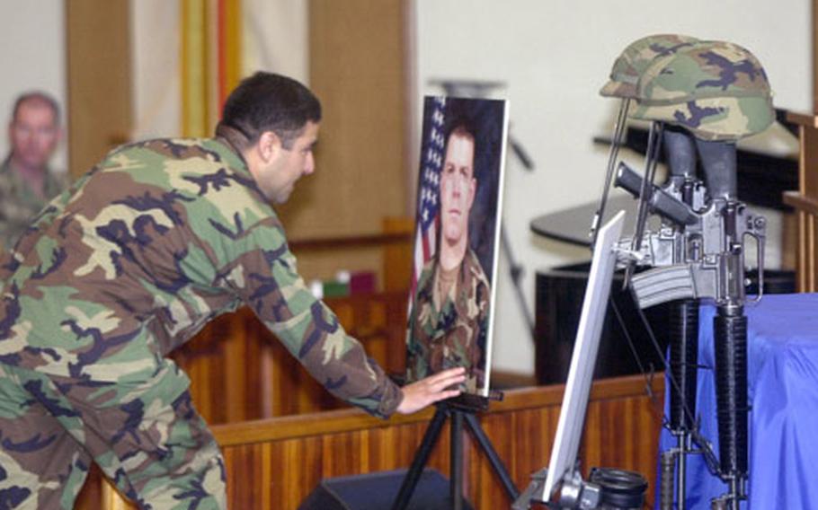 A mourner pays his final respects at a memorial service for Capt. Kevin M. Norman and CW3 David W. Snow, who were killed in 2003 when their C-12 Huron crashed near Camp Humphreys.