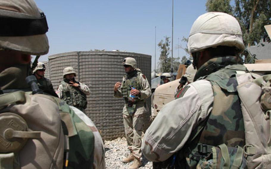 Sgt. Michael Davis, center, gives a safety briefing to soldiers from Company C, 82nd Engineer Battalion, out of Bamberg, Germany, Saturday at Forward Operating Base Gabe, Iraq. The soldiers, from the 3rd and 4th platoons, were about to patrol "Blue Babe Highway" in search of roadside bombs.