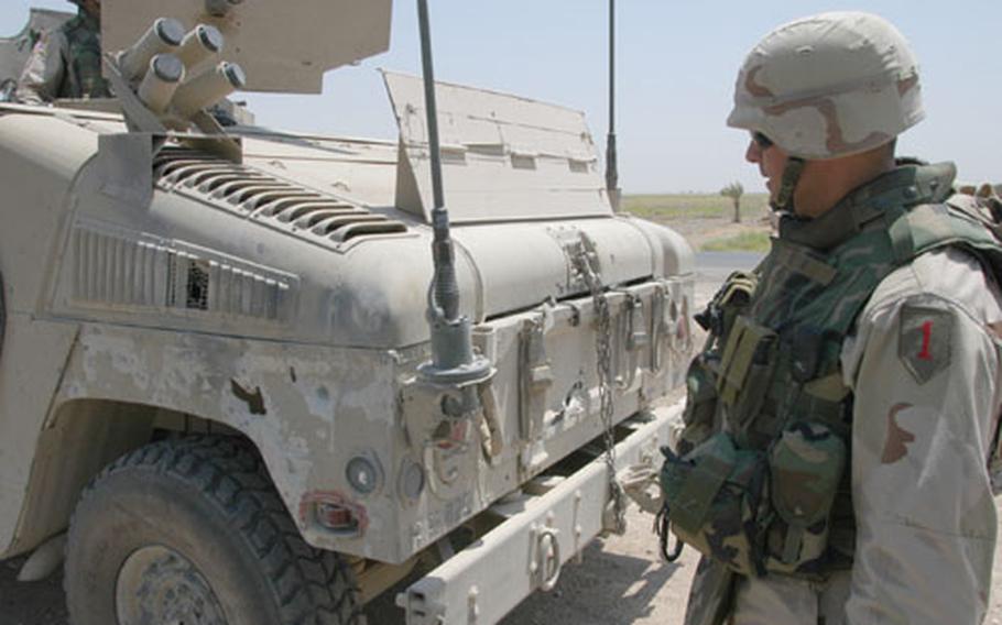 Command Sgt. Maj. John Gioia, 82nd Engineer Battalion, stands next to his shrapnel-scarred Humvee last week. Soldiers from his battalion conduct patrols in search of roadside bombs on the same roadway, known as "Blue Babe Highway," where the damage to his vehicle was caused in June.