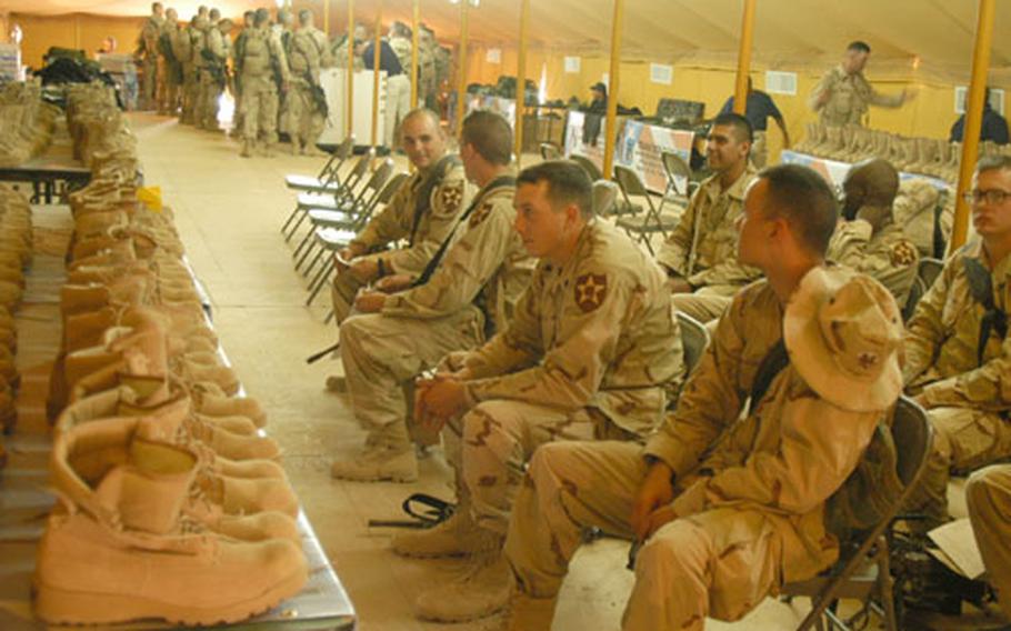Soldiers from 1st Battalion, 506th Parachute Infantry Regiment wait to recieve new equipment at Camp Buehring, Kuwait.