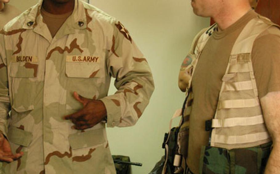 Staff Sgt. Keith Bolden, left, and Pfc. Arthur Waddle of Company C, 2nd Forward Support Battalion discuss the advantages of the Modular Lightweight Load Carrying Equipment vest at Camp Buehring, Kuwait.