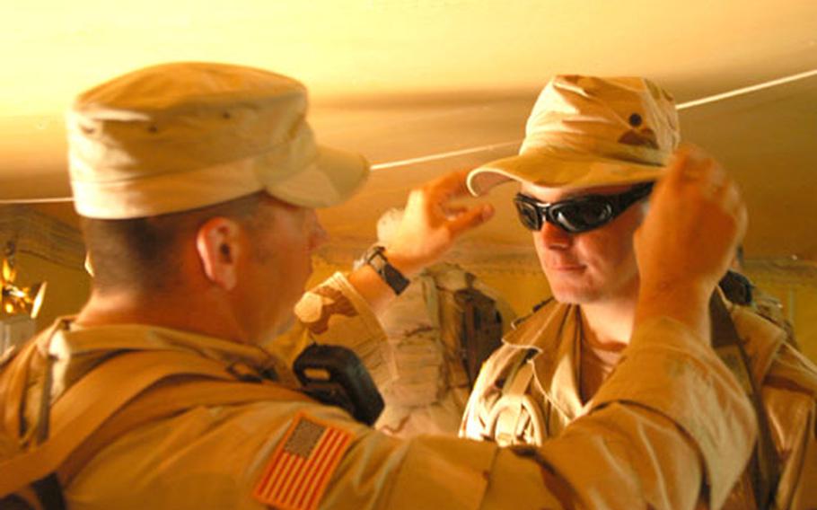 A soldier from 1st Battalion, 506th Parachute Infantry Regiment tries on a pair of Wiley X sunglasses issued to him at Camp Buehring, Kuwait.