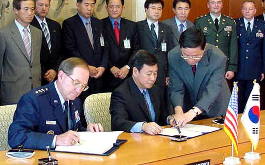 USFK deputy commander Lt. Gen. Garry R. Trexler, left, and Ministry of Foreign Affairs and Trade official Kim Sook sign an agreement Monday setting an April 2005 target date for a pipeline replacement.