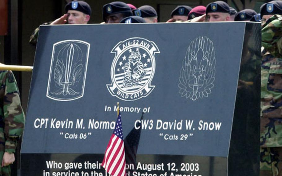 Members of the 6th Battalion, 52nd Aviation Regiment, salute during the dedication of a memorial to two pilots killed last year in a plane crash.
