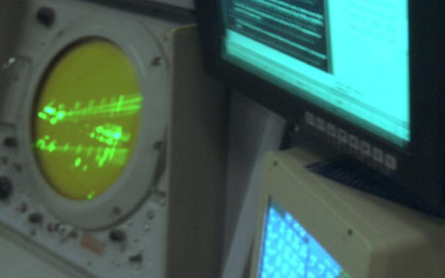 Two new computer consoles on the left, sit next to the old Precision Approach Radar blip screen inside the new Radar and Air Traffic Control Facility at Naval Station Rota, Spain.