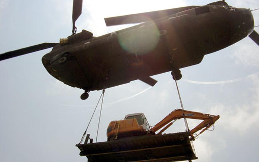 A CH-47 Chinook helicopter of Company A, 2nd Battalion, 52nd Aviation Regiment out of Camp Humphreys, South Korea, hauls a piece of construction equipment to a U.S. Army communications site atop a mountain near Kumi City on Monday. The Army&#39;s 36th Signal Battalion at Camp Walker in Taegu is demolishing old buildings at the site and plans to upgrade its radio equipment there.