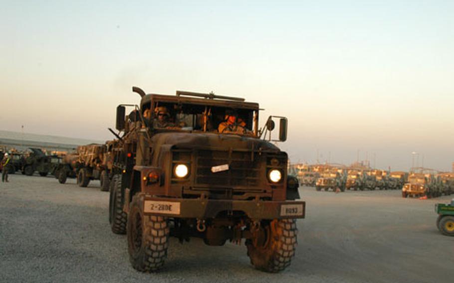 The first Strikeforce convoy rolls from port in Kuwait headed for Camp Buehring on Tuesday. South Korean vehicles deploying at the same time are assembled in the background.