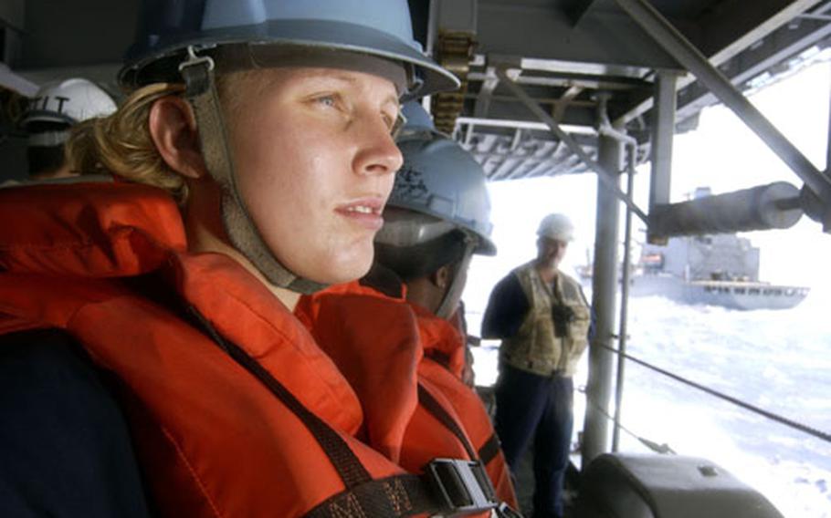 Seaman Kim Tromburgh of Boise, Idaho, stands by while the USS Kitty Hawk comes alongside the replenishment oiler USNS Yukon to conduct replenishment at sea.