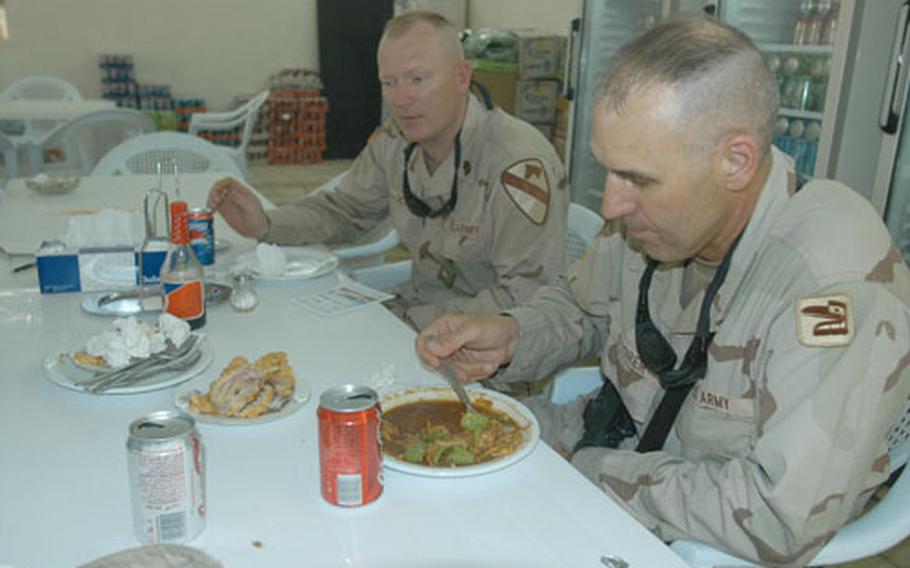 Sgt. 1st Class Larry Storer of the 1st Battalion, 161st Infantry Regiment of the Washington state Army National Guard, finishes his Chinese lunch in Baghdad&#39;s International Zone. Behind him is 1st Sgt. Wililam Tager of the 3rd Battalion, 8th Cavalry Regiment.