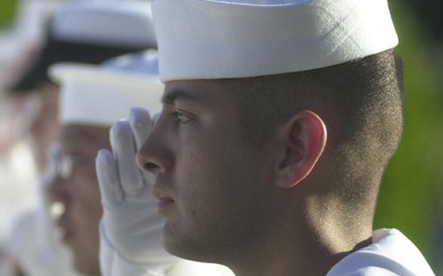 U.S. sailor from Naval Station Rota, Spain, salutes during the national anthem Saturday at Rhone American Cemetery in Draguignan, France.