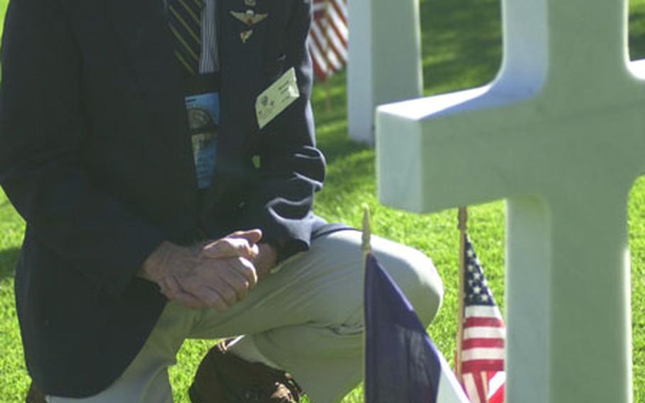 Military veteran Gene Frice kneels before a grave at Rhone American Cemetery in Draguignan, France.