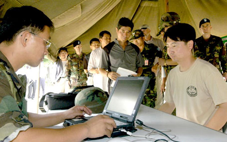 Clerks enter key personal information into a computer network as members of the U.S. Army’s Korean Service Corps Battalion rehearse their wartime procedures for setting up and operating mobilization stations on the grounds of Pyongil Elementary School in Pyongtaek, South Korea. In wartime the battalion’s noncombatant laborers drive ambulances, build fortifications, and recover battle casualties.