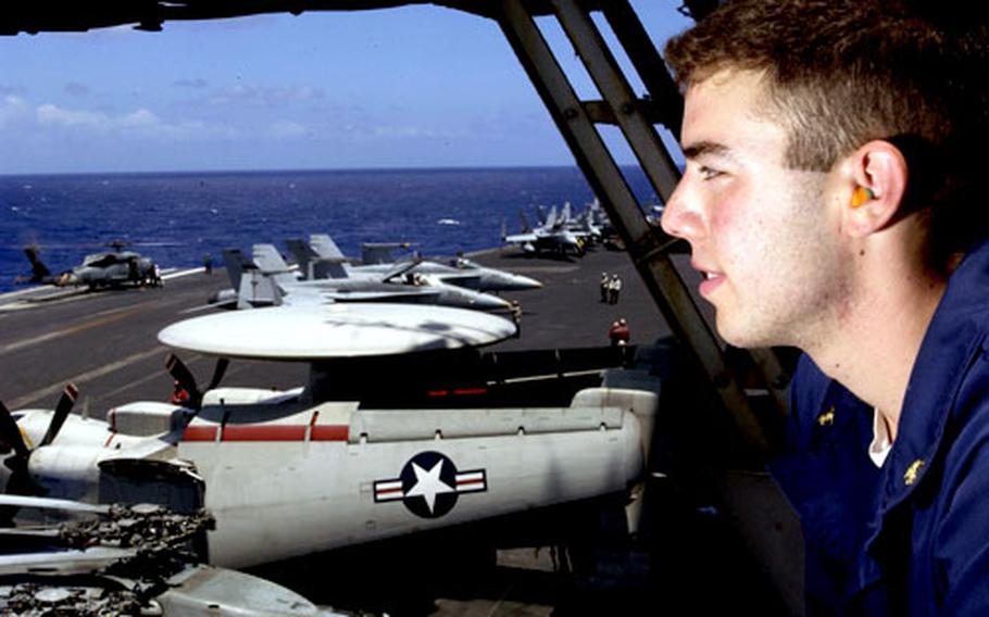 Midshipman 1st Class Yuval Fleming of Tucson, Ariz., enjoys the view from vulture&#39;s row as an SH-60 Seahawk helicopter from Helicopter Anti-submarine Squadron 14 prepares to launch from the flight deck of the USS Kitty Hawk.