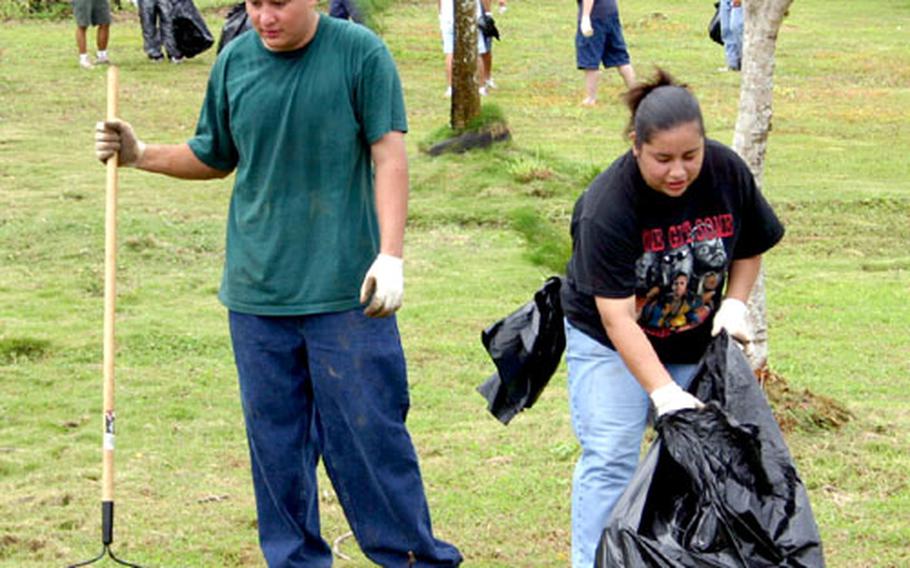 Gabriela Quintanilla and her husband Eli, both members of the HC-5 helicopter squadron, help clean up the schoolyard at F.B. Leon Guerrero Middle School in Yigo, Guam.