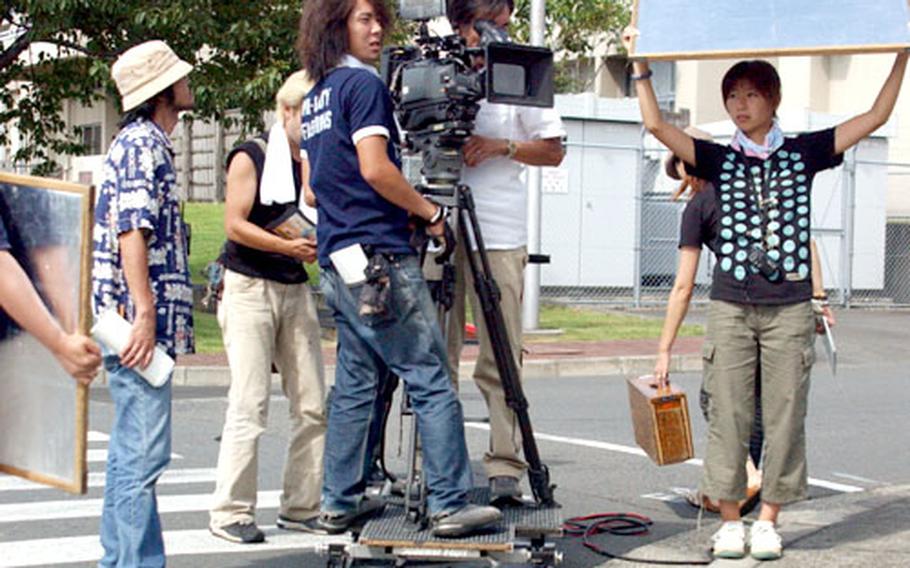 The CineHouse film crew, including, Masayuki Kawada, main cameraman, and Satoru Hasegawa, his assistant, adjust the camera angle during Monday’s scene filming at Camp Zama.