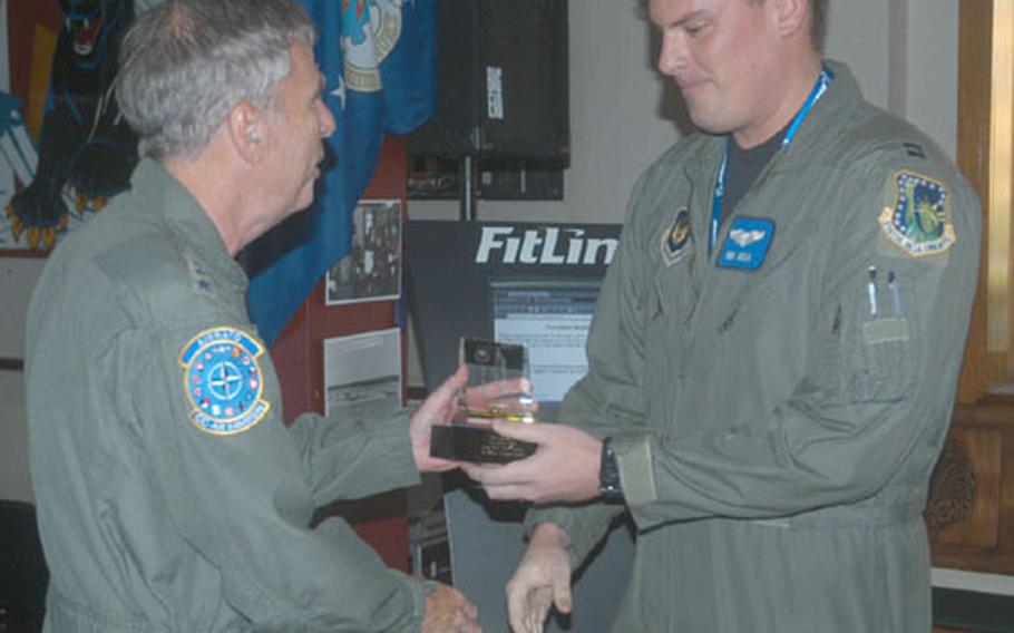 Capt. Ben Heslin, an F-15E Strike Eagle pilot with the 492nd Fighter Squadron at RAF Lakenheath, England, accepts an award Thursday from Gen. Robert H. "Doc" Foglesong. The award was for Heslin&#39;s performance in the Excalibur bombing competition held in England.