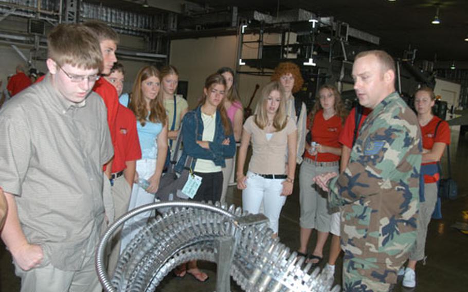 Tech. Sgt. Chance Nichols, a lead standardization crewmember with 35th Maintenance Group at Misawa Air Base, Japan, shows students from Wenatchee, Wash., ammunition for an F-16. A delegation of students, parents and civic leaders from Wenatchee, Misawa&#39;s sister city, visited Misawa last week, stopping by the base Friday for a tour and lunch.