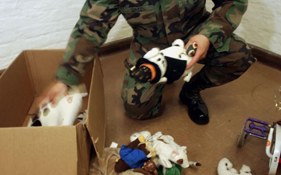 Spc. Troy Green, a member of the Missouri National Guard called up to work as a military policeman in Darmstadt, Germany, shows his softer side as he goes through a box of toys donated to needy children.