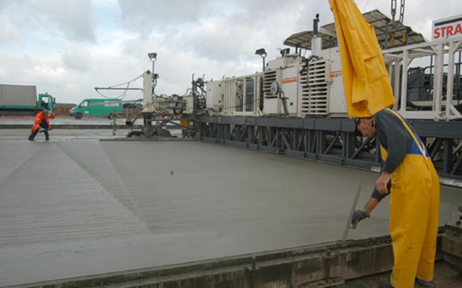 Workers smooth the edges of Spangdahlem&#39;s newly poured concrete ramp, which will hold up to 11 wide-body planes.