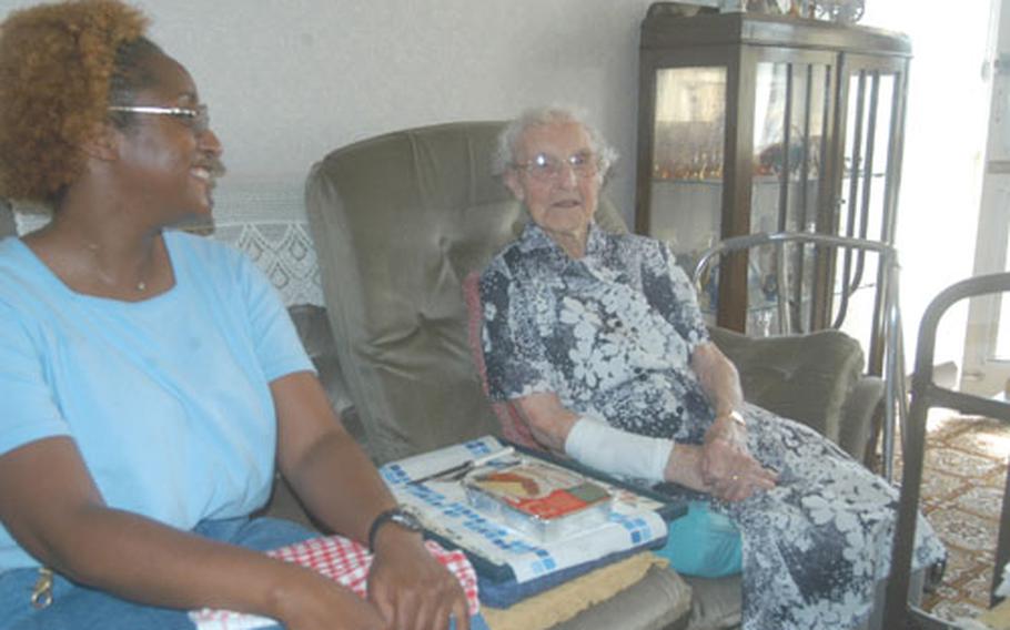 Tandra Thomas, left, who works at RAF Mildenhall, England, chats with Grace Royal, 101, in Brandon, England. Thomas delivers Meals on Wheels to Royal and several other people in the town near the large U.S. bases in eastern England.