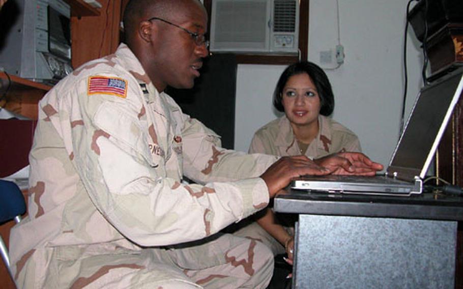 Capt. Reggie Kornegay, a civil affairs officer with the 478th Civil Affairs Battalion who is attached to the 1st Battalion, 9th Cavalry Regiment in Baghdad, goes over last-minute preparations for the inaugural class of the Iraqi Police Leaders Operational Assistance and Development Course with translator Nora Issam.