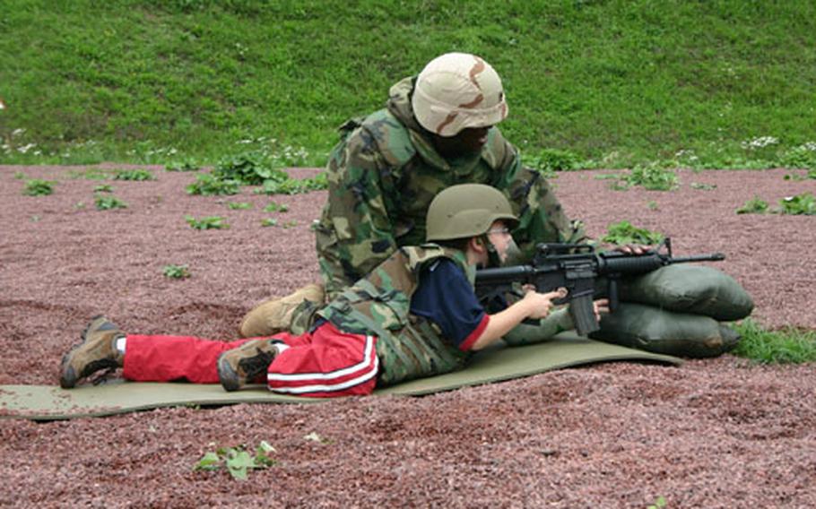 Staff Sgt. Bernard Brown encourages third-grader Joshua Zeeman after a series of successful shots. The boys practiced with several rounds of blanks before shooting live ammunition.