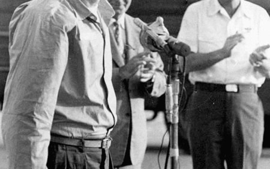 Navy Capt. Leo Profilet, the senior officer on the day's first flight of returning POWs, is all smiles as he addresses the crowd at Clark Air Base in the Philippines.