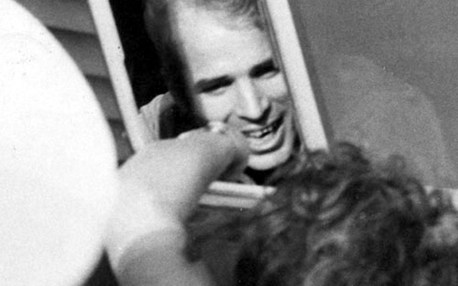 Lt. Cmdr. John S. McCain III talks with a well-wisher after boarding a bus at Clark Air Base.