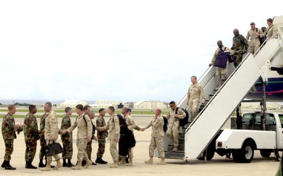 Servicemembers leave the plane at Kadena on their way back from deployment.