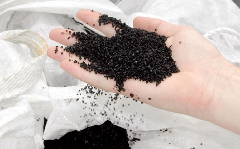 This rubber-like substance will soon be spread over the artificial turf installed at Sasebo Naval Base’s Nimitz Park multipurpose athletic field. The rubber granules fill in between and “lift” the blades of plastic grass, making the surface softer and comparable to a natural turf.