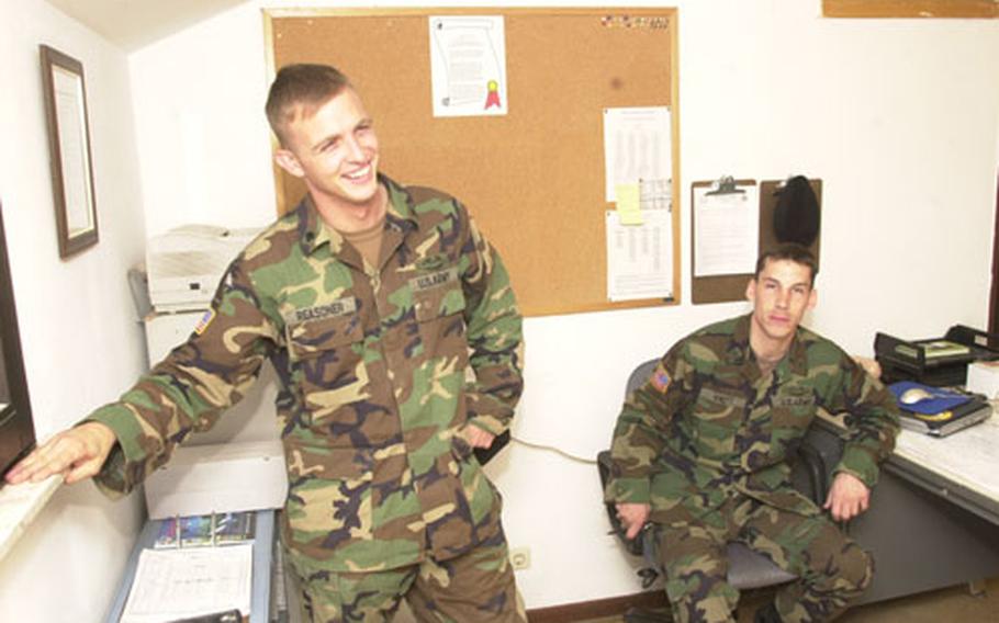 Spc. Joshua Reasoner, left, and Staff Sgt. Eric Knott talk about their time at war while relaxing at Knott&#39;s office at battalion headquarters.