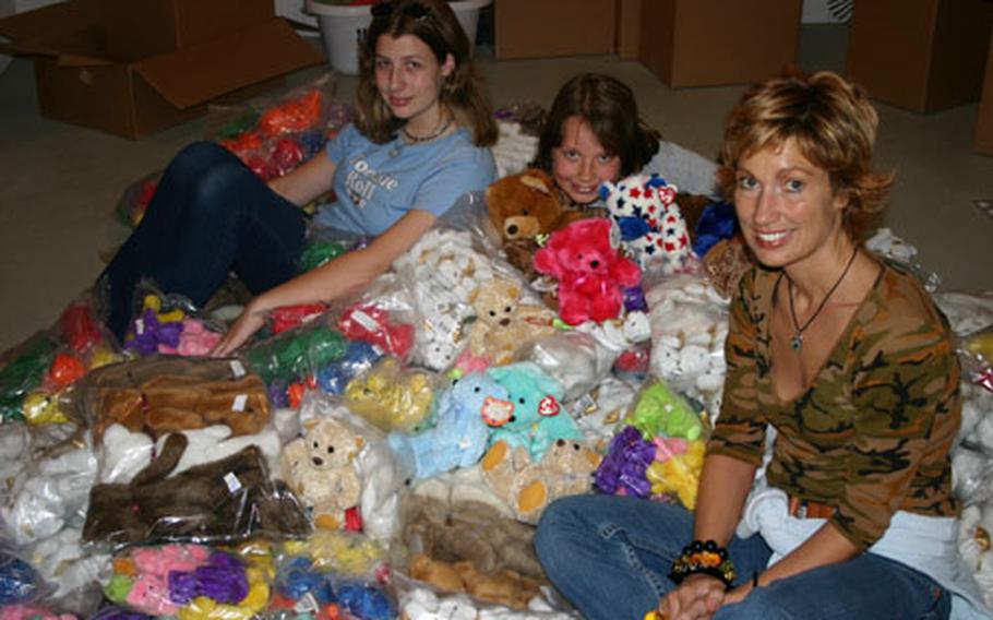 Sandra Hummel, far right, sits among some of the more than 1,600 stuffed bears she has collected for distribution to injured Iraqi children. With her are two daughters, Veneé, 14, left, and Darnelle, 10, who help her with the project. The bears come from donors in the United States and a collection box at the Café Rohr on Ledwards Barracks in Schweinfurt, Germany.
