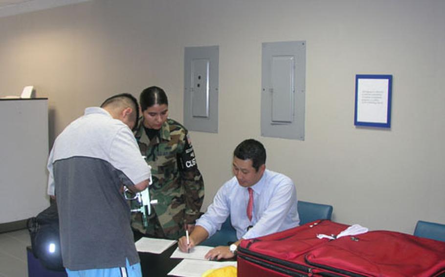 Customs inspectors at Osan Air Base in South Korea fill out paperwork before confiscating a servicemember&#39;s paintball gun. The owner has 30 days to file to reclaim the item. Seated is Rayond Park, an Osan-based customs inspector with United States Forces Korea. Standing, in unfiorm, is Air Force Staff Sgt. Lisa Rodriguez of Osan&#39;s 51st Security Forces Squadron. She&#39;s noncommissioned officer-in-charge of a customs team that works the Osan terminal. (pnw# 61p cs)