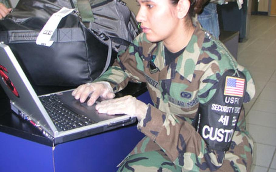Inside the passenger terminal at Osan Air Base, South Korea Thursday, Air Force Staff Sgt. Lisa Rodriguez checks a passenger&#39;s laptop for possible pornographic images. Rodriguez, of Osan&#39;s 51st Security Forces Squadron, is noncommissioned officer-in-charge of a customs team that works to prevent outlawed items from getting into South Korea.