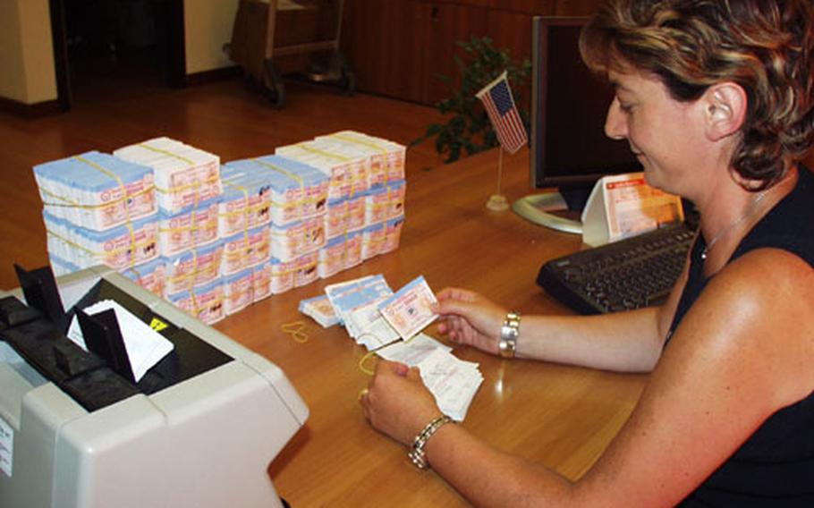 Sandra Sambri, a tax-free clerk at Capodichino in Naples, Italy, checks gas coupons to see if they have signatures. Used gas coupons are returned to the tax-free office on base, where employees check them to ensure they are filled out.