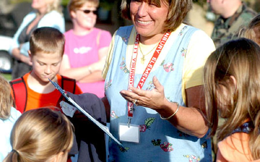 Penny Butler, who teaches fifth and sixth grades at Alconbury Elementary School, RAF Alconbury, England, greets some of her students Tuesday on the first day of school.
